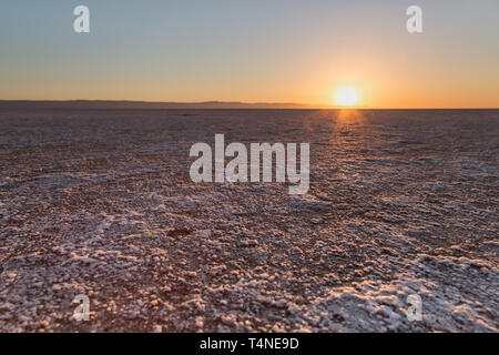 Sonnenaufgang am Chott el Djerid - Salt Lake in Tunesien in der Sahara. Ersten Strahlen der Morgensonne über dem Horizont. Stockfoto