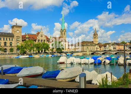 Zürich, Schweiz - 1 August 2016: Boote auf dem Fluss Limmat, Gebäude entlang des Flusses, Uhr Türme der Fraumunster und St. Peter Kirche. Züri Stockfoto