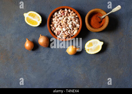 Prebranac Zutaten. Balkan gebackene Bohnen. Serbisch, Montenegrinisch, bosnischen, kroatischen und slowenischen Küche. Rohe Bohnen, Zwiebeln, Zitrone, Paprika Pulver Stockfoto