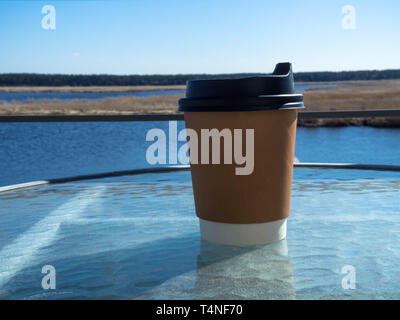 Papier Tasse Kaffee aus Papier auf Glas Tisch morgen Hintergrund. Film Effekt Stockfoto