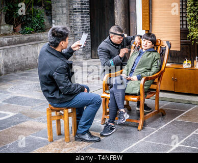 22. November 2017, Chengdu Sichuan China: Chinesische Frau tut das Ohr - Reinigung in der breiten und schmalen Gassen von Chengdu mit ihrem Freund unter Pict Stockfoto