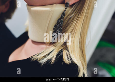 Nahaufnahme Seite Profil der blonde junge Frau mit Haare im Zopf und Tragen Neck Brace. Stockfoto