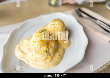 Ei Benedikt auf warmen Toast Brioche. Zwei Eier, leckeren Sauce Hollandaise. Licht am Morgen das Frühstück auf dem Tisch im Restaurant. Stockfoto