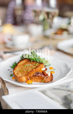 French Toast Brioche, Sandwich mit Pastrami und getrocknete Tomaten. Licht morgen Frühstück, frisches, warmes Gebäck auf dem Tisch im Restaurant Stockfoto