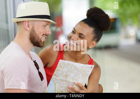 Gut aussehendes Paar in der Stadt lesen Karte verloren Stockfoto