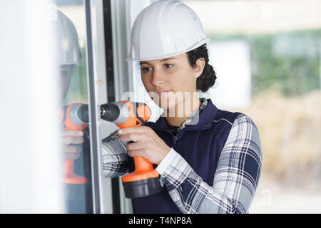 Junge Frau Builder mit Bohrmaschine zu Hause Stockfoto
