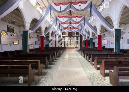 Innenraum der alten leeren katholischen Kirche mit Gebetsständen, religiösen Symbolen und No People. San Juan Dorf, Lake Atitlan Guatemala Highlandss Stockfoto