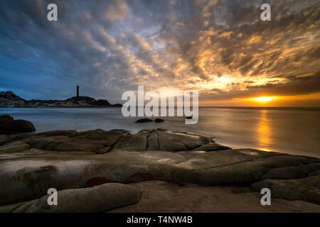 Anzeigen von Ke Ga Leuchtturm bei Sonnenuntergang mit der magischen Wolken. Ke Ga Leuchtturm auf einer kleinen Insel in Ninh Thuan Provinz, Vietnam Stockfoto