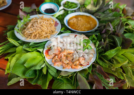 Besondere Kräuter Salat in Kon Tum, Vietnam. Mit den Blättern, um einen kegelförmigen Behälter das Essen zu bringen, und einige Speck, gebratene Garnelen, Slice Stockfoto