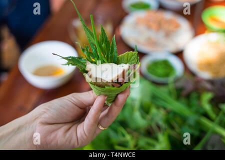 Besondere Kräuter Salat in Kon Tum, Vietnam. Mit den Blättern, um einen kegelförmigen Behälter das Essen zu bringen, und einige Speck, gebratene Garnelen, Slice Stockfoto