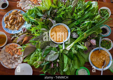 Besondere Kräuter Salat in Kon Tum, Vietnam. Mit den Blättern, um einen kegelförmigen Behälter das Essen zu bringen, und einige Speck, gebratene Garnelen, Slice Stockfoto