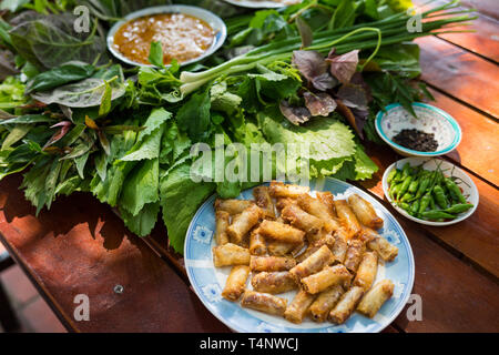 Besondere Kräuter Salat in Kon Tum, Vietnam. Mit den Blättern, um einen kegelförmigen Behälter das Essen zu bringen, und einige Speck, gebratene Garnelen, Slice Stockfoto