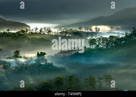 Schöne Bilder von der leuchtenden Morgenröte mit reflektierenden Sonnenstrahlen durch die phantasievoll Wolken über die Pinienwälder, die eine beeindruckende breathtaki erstellt Stockfoto