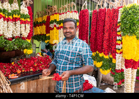 Horizontale Ansicht eines Mannes die Girlanden an Mattuthavani Blumenmarkt in Madurai, Indien. Stockfoto