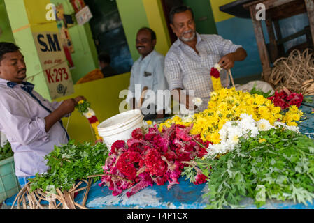 Horizontale Ansicht der Männer die Girlanden an Mattuthavani Blumenmarkt in Madurai, Indien. Stockfoto