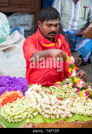 Vertikale Porträt eines Mannes verkauf Jasmin Girlanden an Mattuthavani Blumenmarkt in Madurai, Indien. Stockfoto