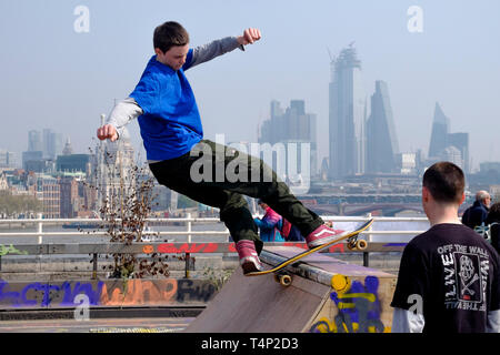 Skateboarder vor der Kulisse der City of London während des Extinction Rebellion Besetzung der Waterloo Bridge, April 2019. Stockfoto