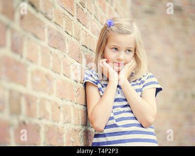 Mädchen, 10 Jahre, lehnt sich gegen eine Wand, schüchtern, Porträt, Deutschland Stockfoto