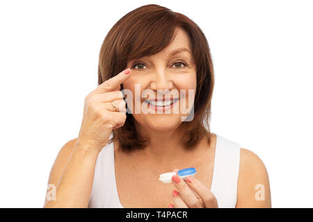 Gesundheit, Vision und alte Menschen Konzept - Glücklich lächelnde ältere Frau auf Kontaktlinsen auf weißem Hintergrund Stockfoto