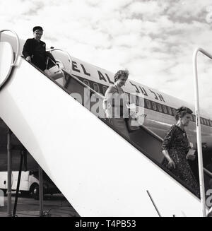 1960, historische, erwachsenen weiblichen Passagiere von Bord gehen Sie einige Schritte aus einer El Al Boeing 707-Flugzeuge am Flughafen Heathrow, London, England, UK geparkt. Stockfoto