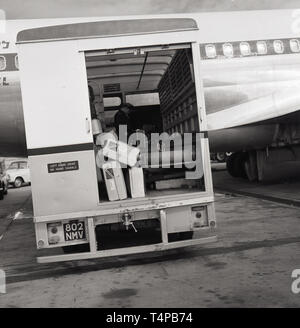 1960, historische, Flughafen Heathrow, London, England, UK. Bild zeigt die geöffnete Rückseite der. "Linker Antrieb "Van mit internen Förderband neben einem Flugzeug auf der Landebahn, die der Fluggast das Gepäck von der Ebene geparkt. Stockfoto