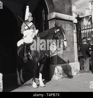 1960, historische, London, Sommer und ein Rettungsschwimmer der Household Cavalry montiert reigment in voller zeremoniellen Uniform saß auf seinem Pferd auf Wache, Stockfoto