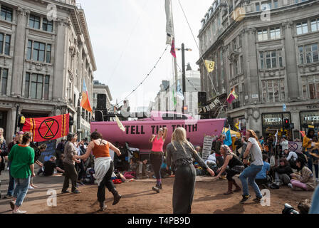 "Demonstranten Aussterben Rebellion' Tanz als Sie besetzen Oxford Circus mit einem hellen Rosa Yacht mit einer "Wahrheit" zu unterzeichnen. Stockfoto