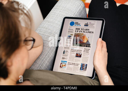 Paris, Frankreich, 15.April 2019: Frau lesen USA heute auf dem iPad pro Apple News Plus digitale Zeitung mit Nachrichten auf der Abdeckung der französischen Kathedrale Notre-Dame auf Feuer Schäden verursachen Stockfoto