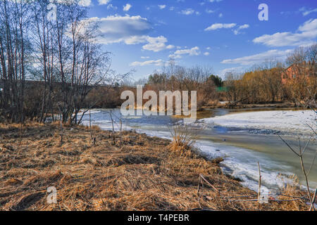 Der frühe Frühling Landschaft schmilzt Eis auf einem kleinen Fluss am Rande des Dorfes. Stockfoto