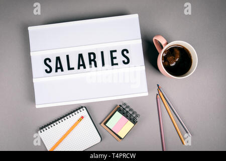 Löhne und Gehälter. Text in Leuchtkasten Stockfoto