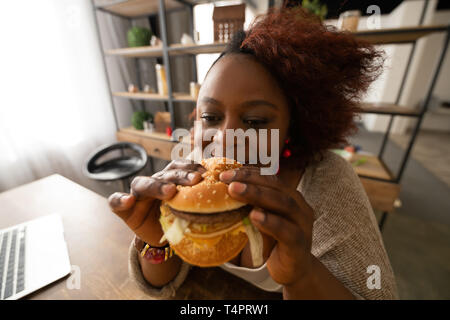 Es riechen. Freundliche internationale weibliche zum Ausdruck Positivität und genießen Sie verboten Essen Stockfoto