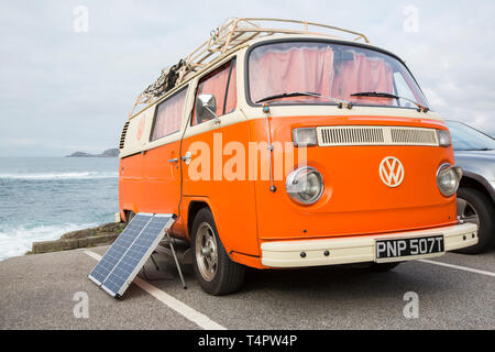 Ein VW Wohnmobil mit einem Solarpanel in Sennen, Cornwall, UK. Stockfoto