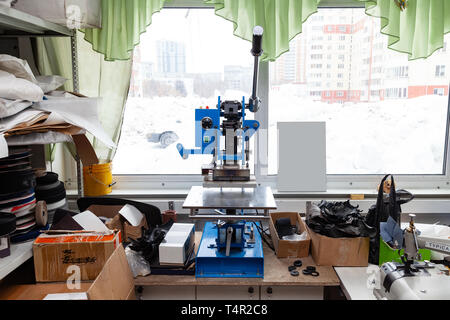 Drücken Sie die Maschine in der Werkstatt für das Tun der geprägtem Logo und Buchstaben auf dem Leder Produkt, das Klischee heizt und drückt das gewünschte Bild auf t Stockfoto