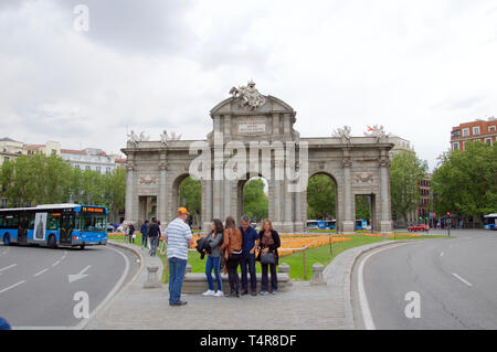 MADRID, Spanien - 17. April: Touristen fotografieren an der Puerta de Alcala bei Sonnenuntergang an einem bewölkten dayon April 17, 2019 in Madrid, Spanien. Stockfoto