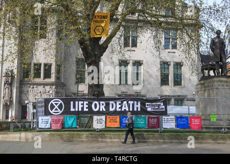 London, Großbritannien. 18 Apr, 2019. Ein Fußgänger geht Vergangenheit Nachrichten außerhalb der Oberste Gerichtshof als Aussterben Rebellion Demonstranten weiterhin Zugang zum Parlament am 4. Tag eines laufenden zivilen Ungehorsam gegen die britische Regierung der Nachfrage zu blockieren Notfall auf die Klimakrise Credit deklarieren: Amer ghazzal/Alamy leben Nachrichten Stockfoto