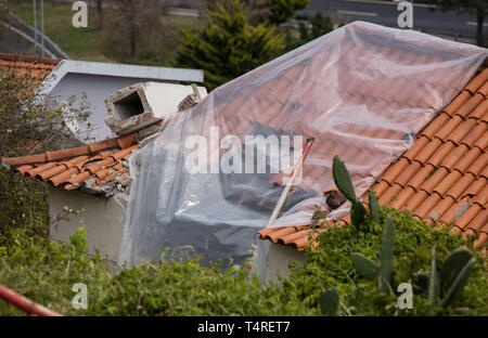 Canico, Portugal. 18 Apr, 2019. Eine beschädigte Stelle auf ein Haus ist spärlich mit einer Plane abgedeckt. Im bus Unfall am 17.04.2019 auf der portugiesischen Insel Madeira im Atlantik 29 Menschen ihr Leben verloren. Nach den bisherigen Feststellungen, es gibt wahrscheinlich viele Deutsche Urlauber unter den Opfern. Credit: Frank Zagel/dpa/Alamy leben Nachrichten Stockfoto