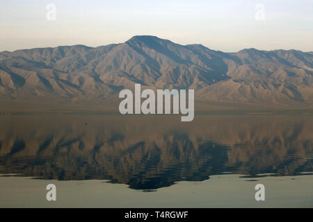 Bombay Beach, Kalifornien, USA. 10 Dez, 2016. Der Salton Sea ist ein flacher, Saline, endorheic rift See direkt auf der San Andreas Störung, vorwiegend in den südlichen Kalifornien Imperial und Coachella Täler. Der tiefste Punkt des Meeres ist 1,5 m (5 ft) höher als der niedrigste Punkt des Death Valley. Die jüngsten Zufluss von Wasser aus dem inzwischen stark kontrollierten Colorado River wurde versehentlich durch die Ingenieure der Kalifornien Development Company im Jahre 1905 erstellt. Die daraus resultierenden Abfluss die engineered Canal überwältigt, und der Fluss floss in den Salton Becken für zwei Jahre, füllen Stockfoto