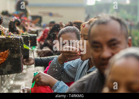 Kathmandu, Nepal. 19 Apr, 2019. Nepalesische devotees Splash heiligen Wasser während Baisdhara mela Full Moon Festival selber. Tausende von Gläubigen versammelten Heiligen Bad in 22 Wasserhosen Balaju für ihre spirituelle Reinigung und in der Überzeugung vieler Erkrankungen Behandlungen zu nehmen. Credit: Sunil Pradhan/SOPA Images/ZUMA Draht/Alamy leben Nachrichten Stockfoto