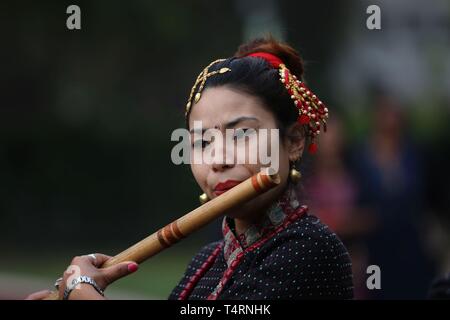 Kathmandu, Nepal. 19 Apr, 2019. Eine nepalesische Dame spielt Flöte in der Feier der Baishak Asnan Festival am Tag des Vollmondes an Balaju, Kathmandu, Nepal, 19. April 2019. Es wird angenommen, dass ein heiliges Bad an diesem Tag reinigt man geistig und macht ihn von Hautkrankheiten. Credit: Sunil Sharma/Xinhua/Alamy leben Nachrichten Stockfoto