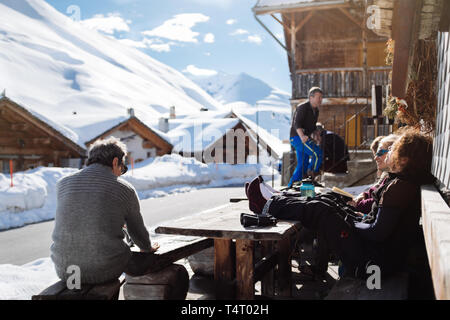 Die Leute draußen sitzen Almhütte in Juf, Schweiz, und genießen die Sonne. Stockfoto