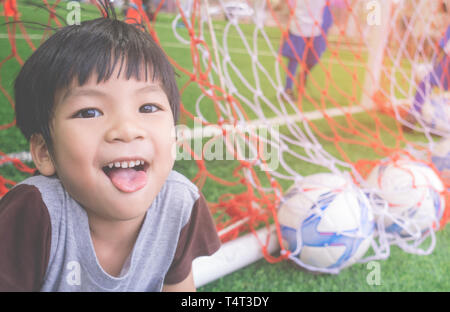 Happy Little Boy hinter dem Tor im Fußball-Training Feld Stockfoto