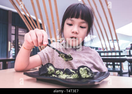 Asiatische Mädchen essen Japanischer Grüner Tee matcha Eis Stockfoto