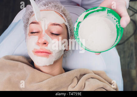 Schöne Frau mit einer kosmetischen Gesichtsbehandlung Peeling Behandlung von professioneller Dermatologe an Wellness Spa. Anti Aging, Gesichtspflege und Luxus leben Stockfoto