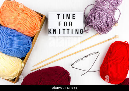 Flatlay von bunten Pastelltönen stricken Knäuel Garn und Stricknadeln mit Schriftzug - Zeit zum Stricken Stockfoto