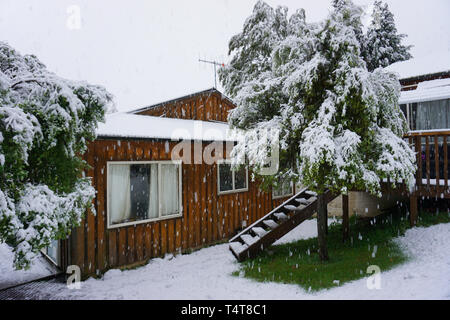 Häuser im Schnee Dicke Schneemann und grüne Bäume Holzhaus mit Treppe in den eisig kalten Wintertag abgedeckt Stockfoto