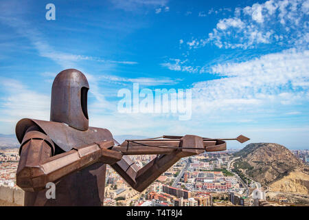 Nahaufnahme der Stahlskulptur des mittelalterlichen Bogenschützen gegen den blauen Himmel über der Burg Santa Barbara, Alicante Spanien Stockfoto