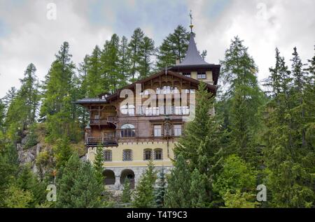 Altes elegantes Haus mit grünen Bäumen, auf einem Hügel in St. Moritz, Schweiz. Stockfoto