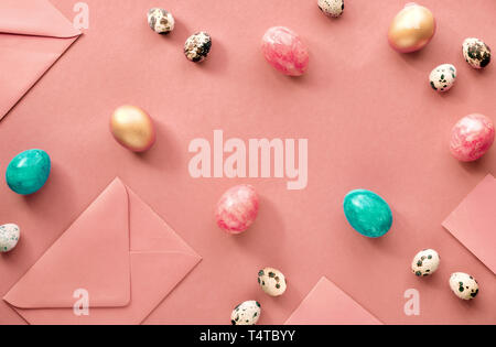 Ostern flach in Coral Farbe mit gemalten Hühner und Wachteln Eier mit leeren Umschläge und Grußkarten Stockfoto