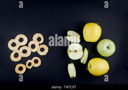 Roh reif geschnittenen Apfel und Frucht Chips auf dunklem Hintergrund, Konzept der gesunden und richtigen Ernährung, Snack, Ansicht von oben, kopieren Raum Stockfoto