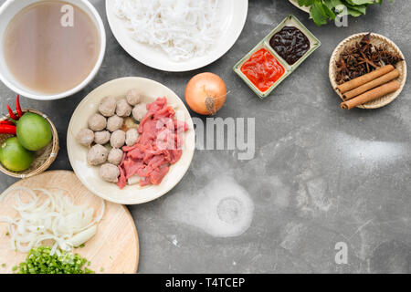 Traditionelle vietnamesische Nudelsuppe pho in Schalen, konkreten Hintergrund. Vietnamesische Rindfleisch Suppe pho bo, Close-up. Asiatische und vietnamesische Küche. Vietnamesische Abendessen Stockfoto